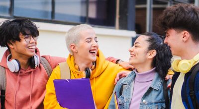 Des étudiants souriants discutent et se tiennent ensemble sur le campus. Photo de haute qualité