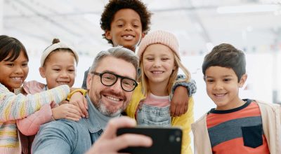 Selfie, crianças e professor com smartphone, felizes e a sorrir para a fotografia, entusiasmados e professor. Criança.