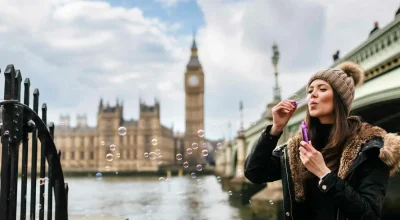 UK, London, young woman blowing soap bubbles