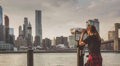 Women looking to New York through a telescope