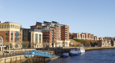 NEWCASTLE, INGLATERRA - 7 DE DEZEMBRO DE 2014: O cais e o caminho da muralha de Adriano com os novos empreendimentos ribeirinhos nas margens do rio Tyne.