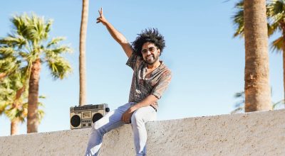 Homem afro-americano a dançar ao ar livre ao som de uma boombox vintage