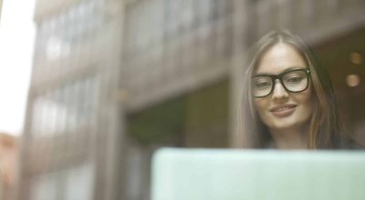 Donna d'affari alla finestra di un caffè che utilizza un computer portatile, Friburgo, Germania