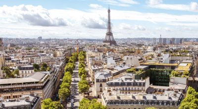 Vista panorâmica aérea de grande ângulo sobre os belos edifícios e avenidas com a torre Eiffel ao fundo durante um dia de sol em Paris