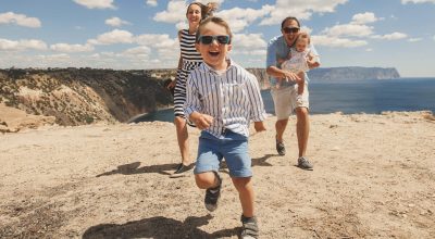 Família feliz de quatro pessoas a caminhar nas montanhas. Conceito de família. Viagem em família.