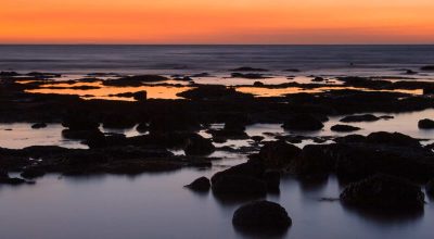 O sol põe-se em East Point numa noite de verão em Darwin, Território do Norte, Austrália